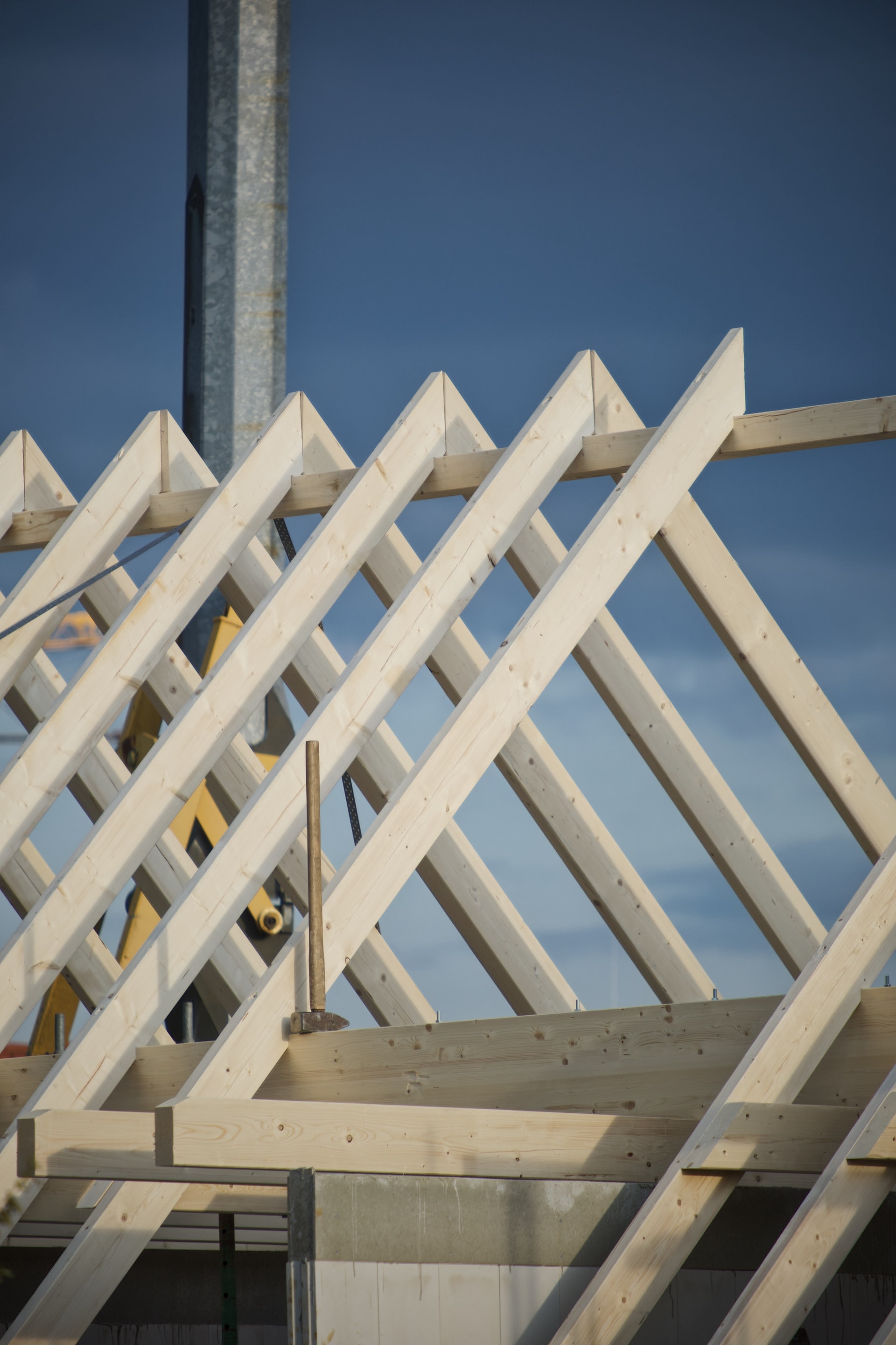 Holzbau Ein Dachstuhl mit Holzbalken in Nahaufnahme, blauer Himmel