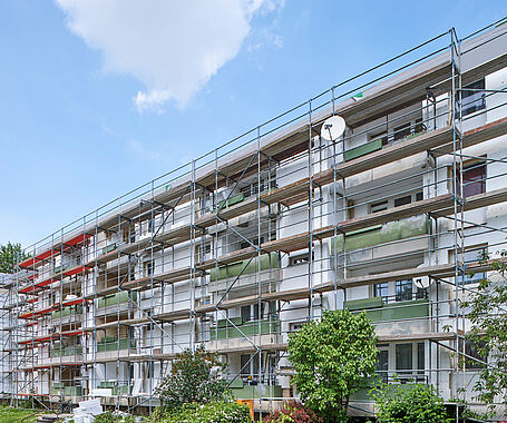 Ein Wohnblock mit einem Gerüst, welcher gerad saniert wird